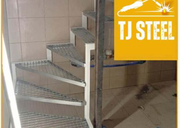 Schody stalowe zabiegowe na wymiar z kratą pomostową wykonane przez TJ Steel do wnętrza budynku